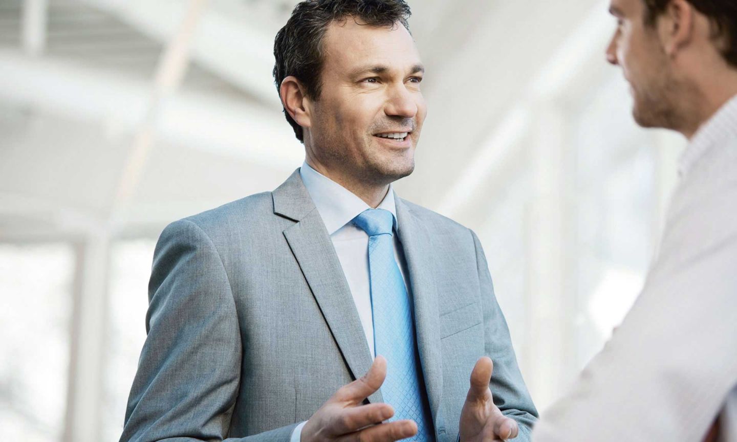 Man in a suit talking to another man